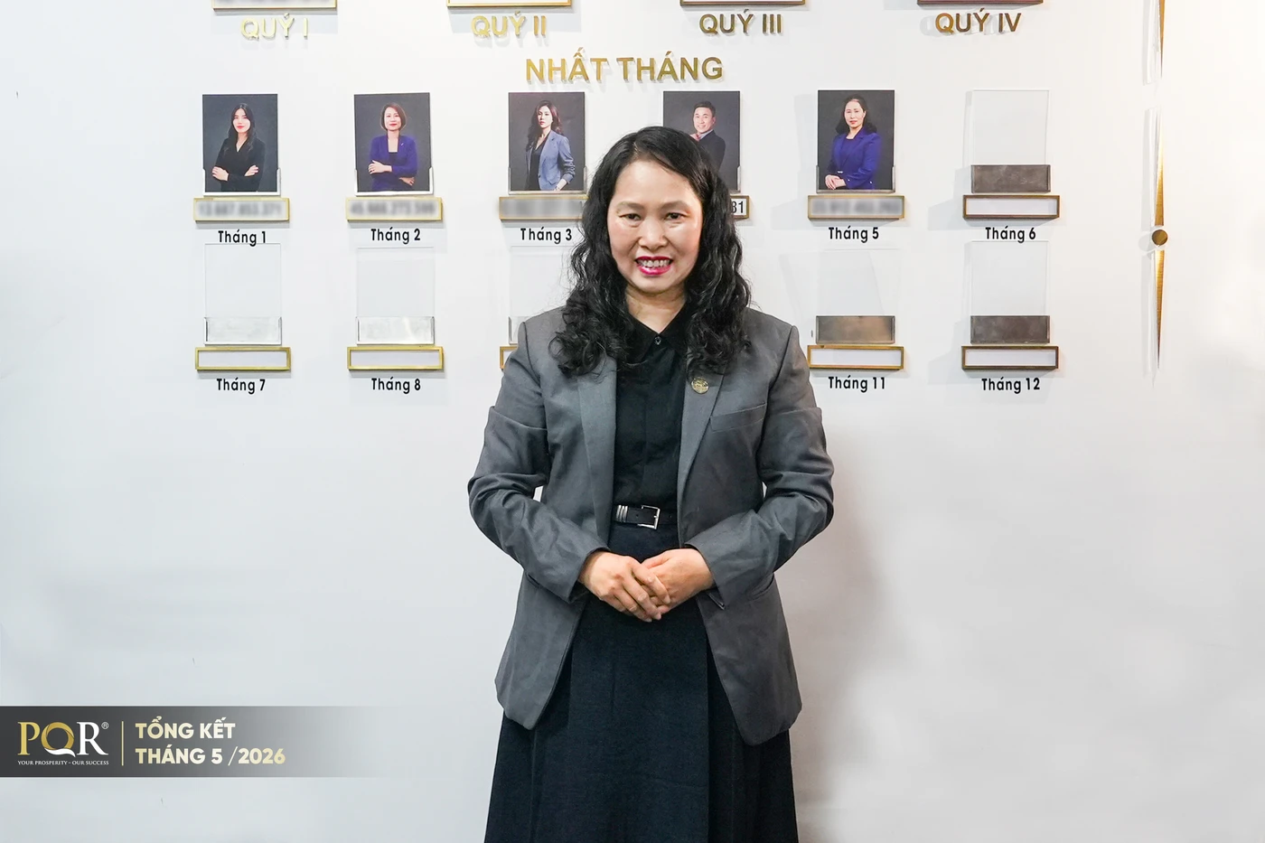 Chị Nguyễn Thị Minh chụp ảnh trước bảng thành tích Nhất Tháng tại văn phòng PQR
